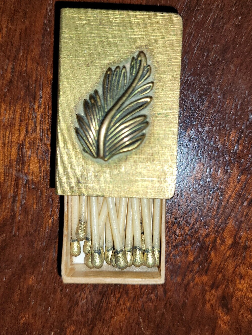 Vintage brass matchbox sleeve featuring an applied embossed brass leaf & Matches